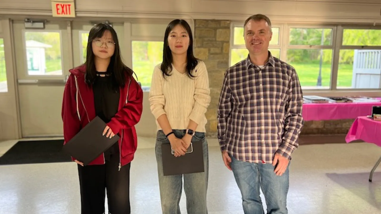 Whitney Award for Research recipients Biqing Yang and Ye Jin Choi standing with Chris Hans in a pavilion